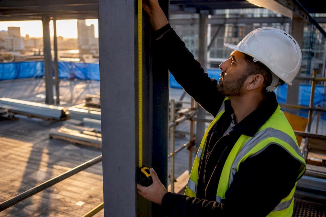 Investor measuring construction wall at site