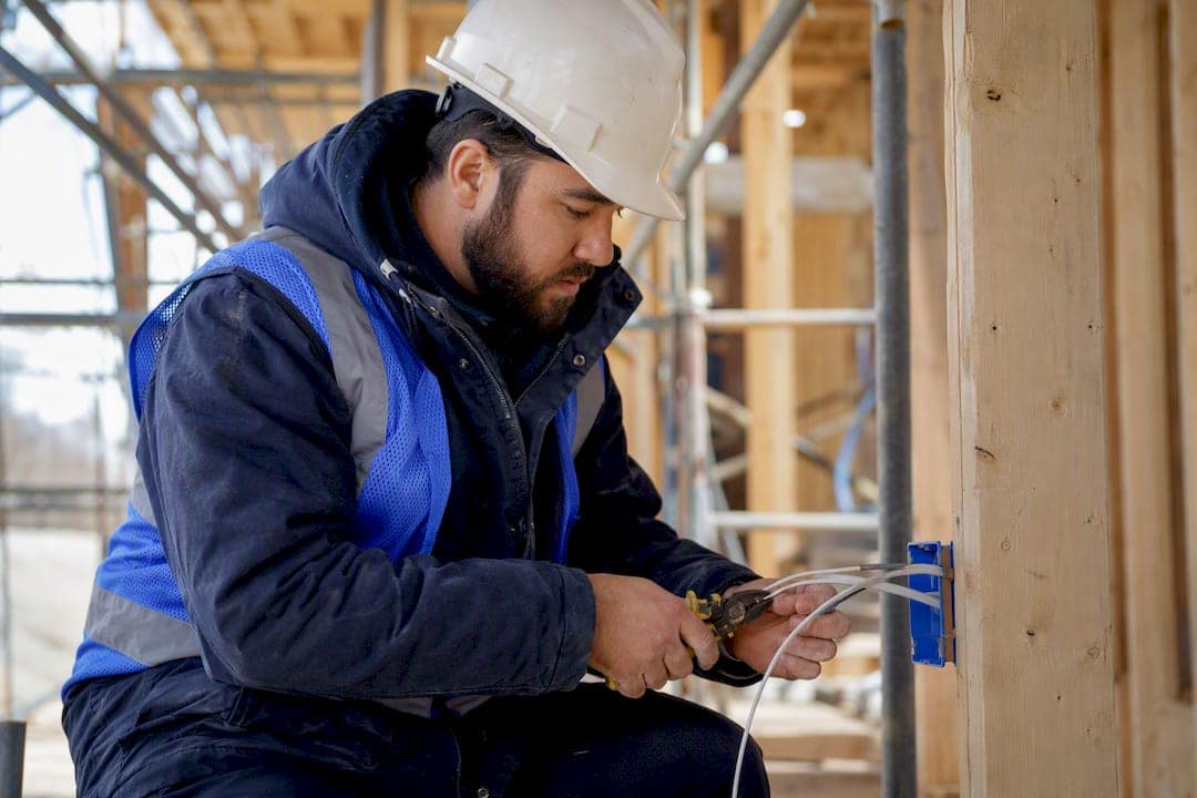 Business owner wiring electrical at real estate construction site